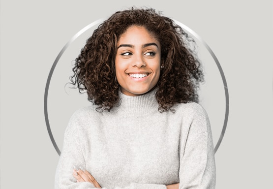 Jeune fille sourit le regard de côté avec un pull blanc gris